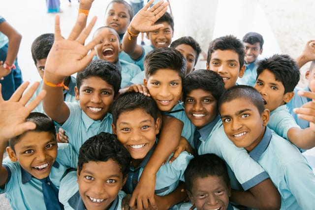 School students gathered together outside a classroom, smiling